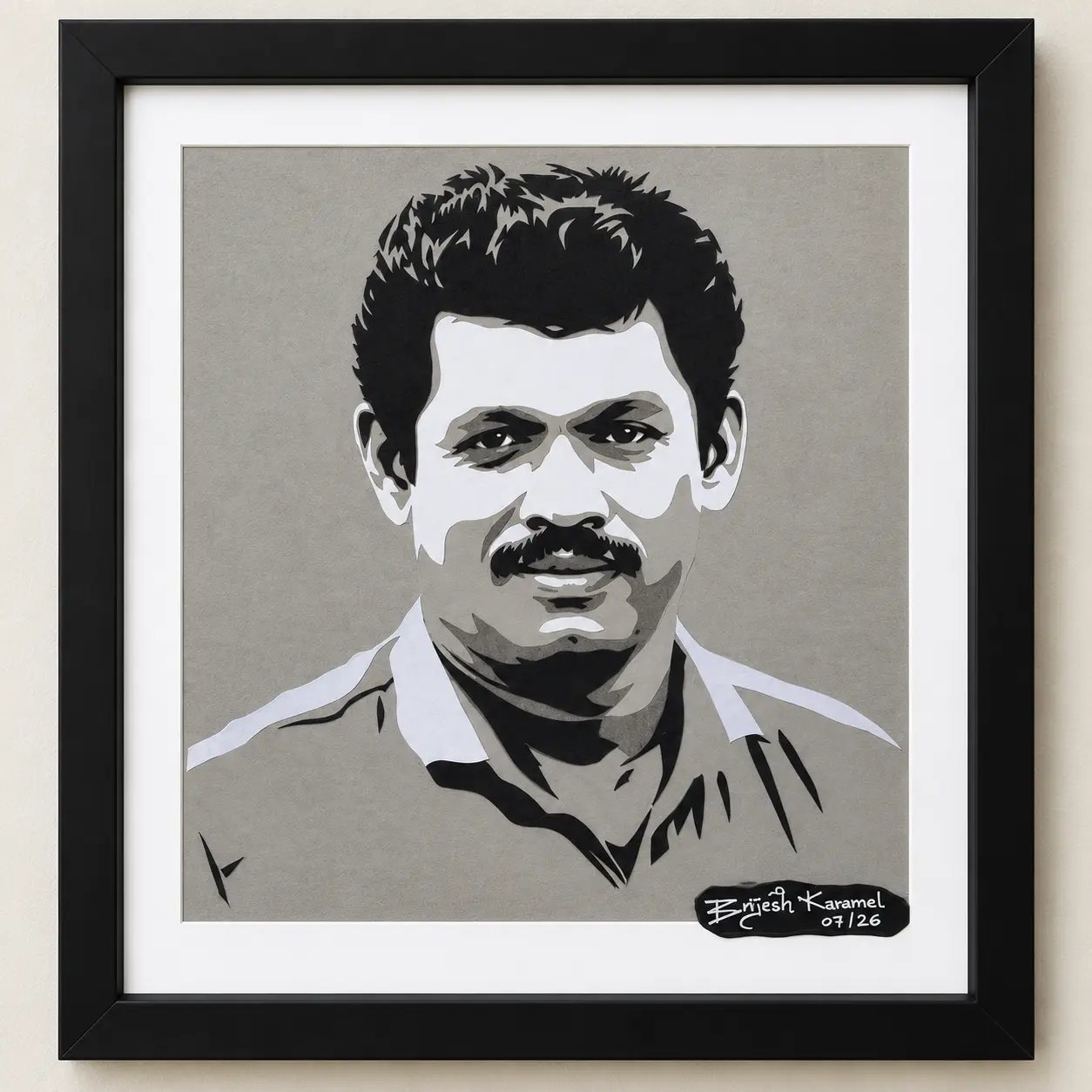 Framed paper-cut portrait of a man with a mustache and wavy hair
