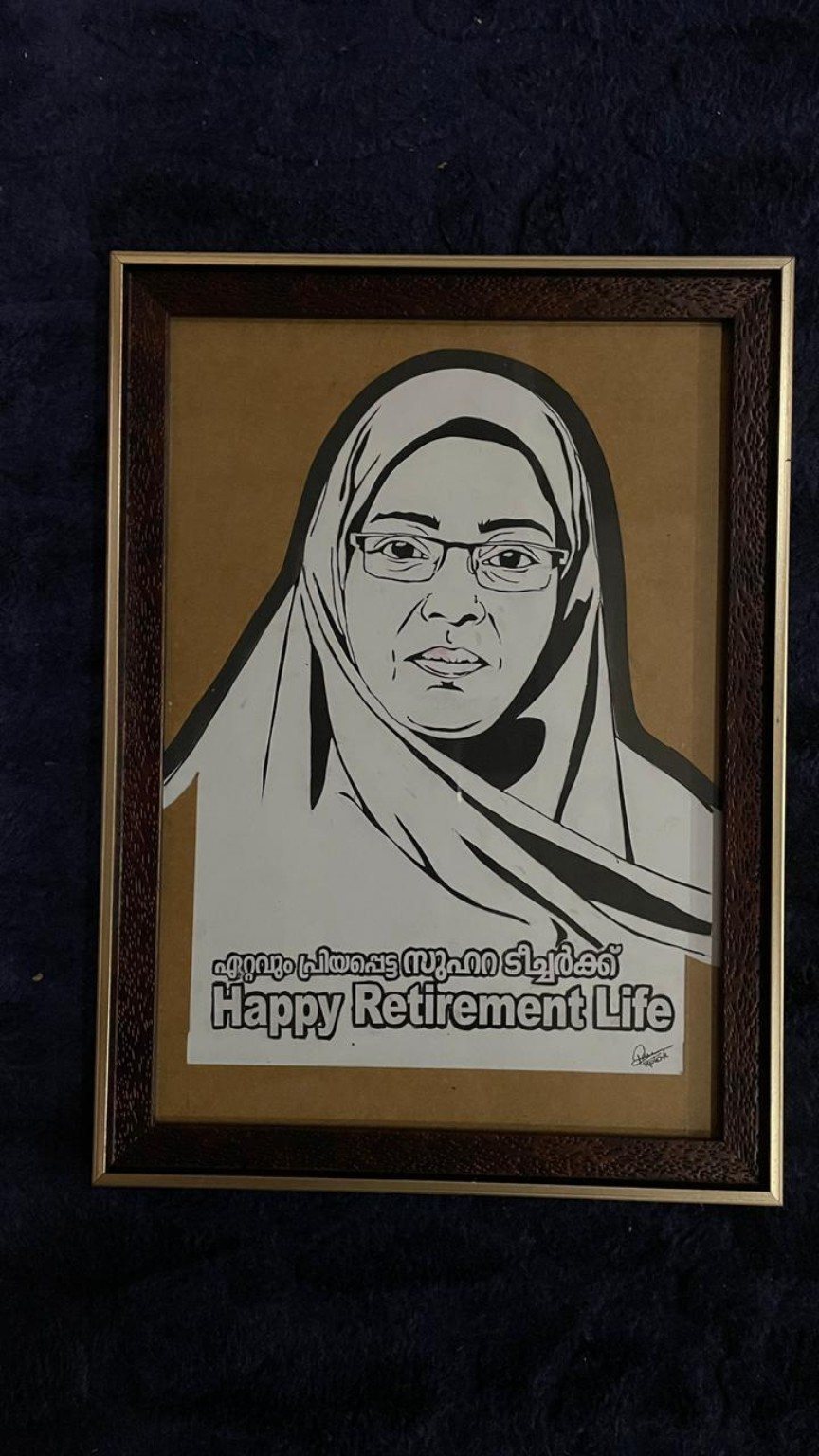Framed paper-cut portrait tribute to a retiring teacher wearing glasses and a headscarf