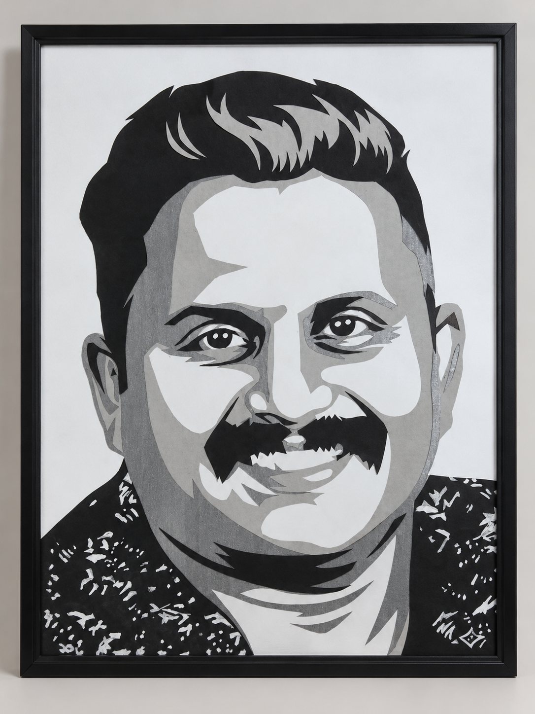 Framed paper-cut portrait of a smiling man with a mustache