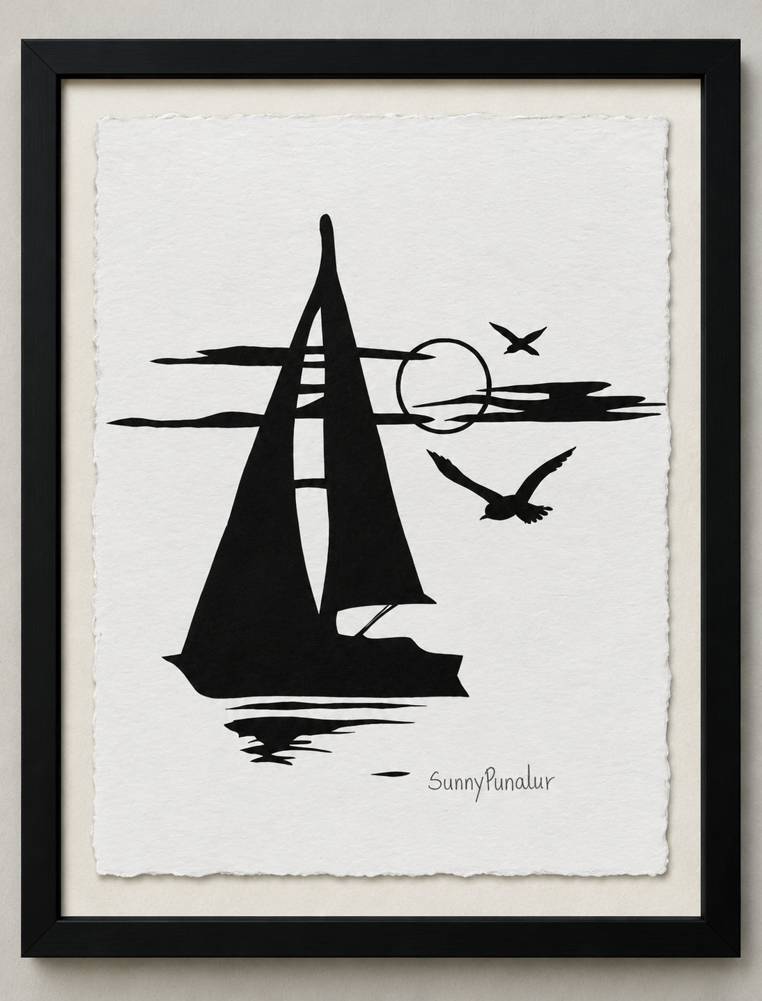 Framed black paper-cut silhouette of a sailboat beneath a sun with gulls