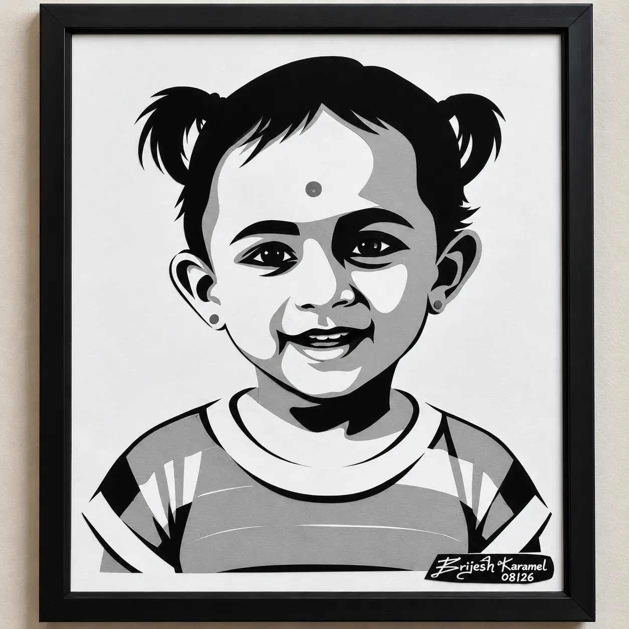 Framed paper-cut portrait of a smiling toddler with pigtails
