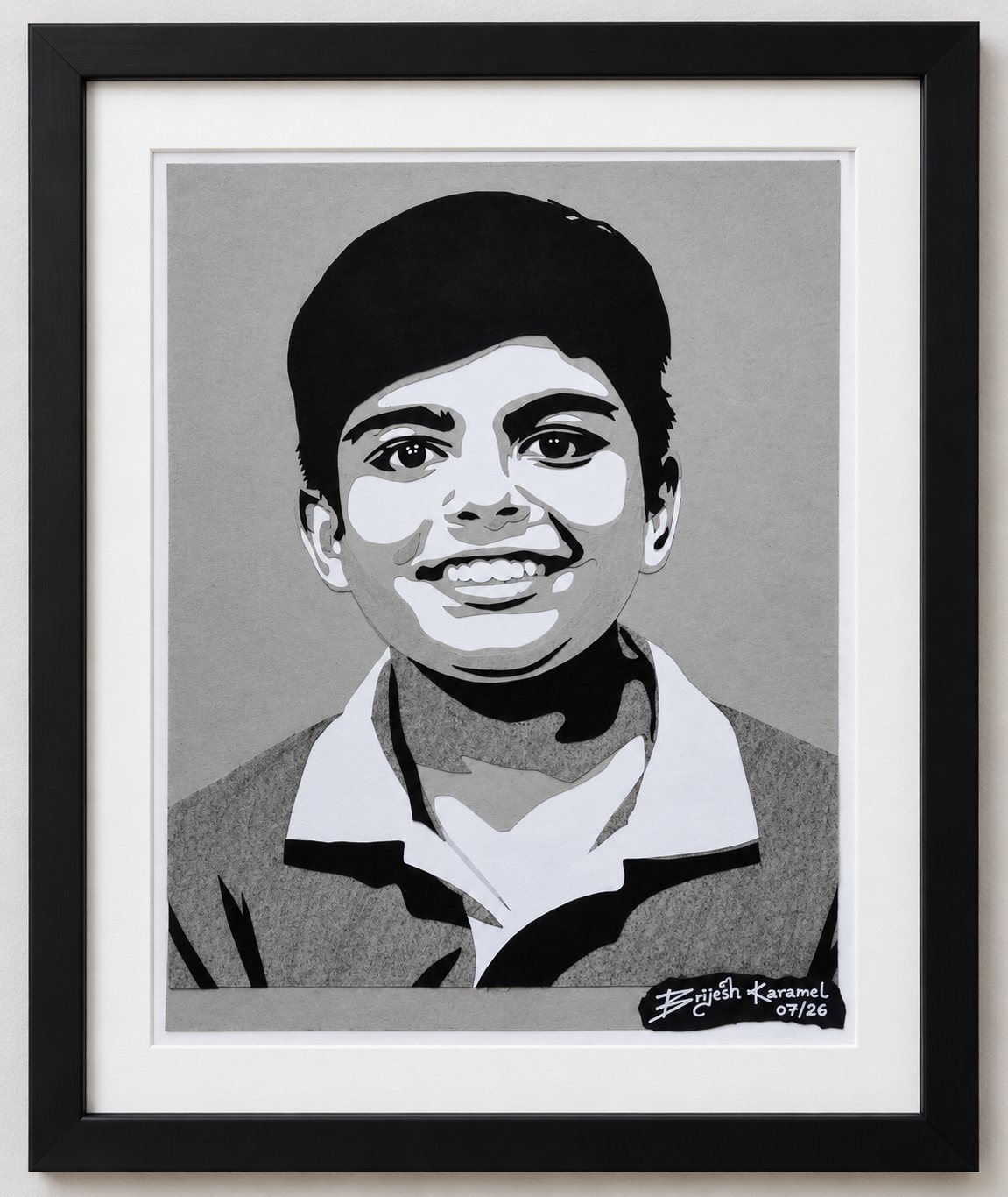 Framed paper-cut portrait of a smiling young boy in a collared shirt